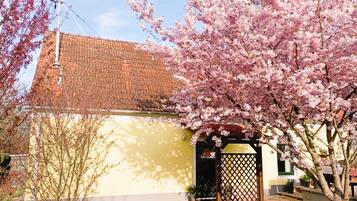 A building with a tiled roof, a yellow facade, and a wooden gate.