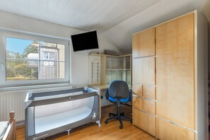 A room with a bed, a desk, a chair, a television mounted on the wall, and a wardrobe. - Vogler Holiday Apartment (Herscheid)