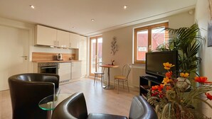 A compact living space with a kitchenette, dining area, and seating.