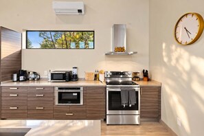 A modern kitchen with a built-in oven, microwave, and coffee maker.