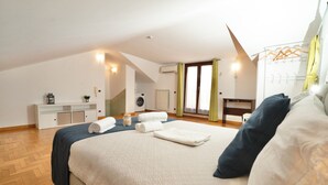 A bedroom with a large bed, a desk, a washing machine, and a radiator. - Villa Antonella Wellness & Jacuzzi (Ciampino)