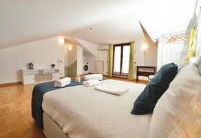 Un dormitorio con una cama grande, un escritorio, una lavadora y un radiador.