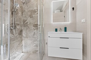 Chuveiro, secador de cabelo, toalhas de banho, papel higiênico