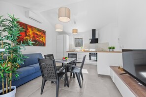 Ein zeitgemäßer Wohnraum mit Essbereich, Sofa und Küche.