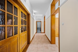 A hallway with wooden doors and a tiled floor.