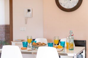 A breakfast table with croissants, orange juice, and a bottle of water. - Villa Miguel Franco (Nerja)