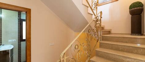 A staircase with ornate metal railings leading to a landing.