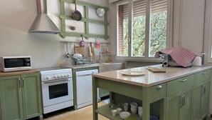A kitchen with a microwave, stove, sink, and green cabinets. - Room & Breakfast D'Annunzio (Ravenna)