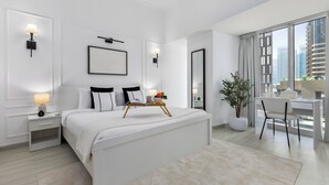A modern hotel room with a large bed, bedside tables, a desk, and a view of the city. - Maison Privee - Sleek Stay in Dubai Marina’s Famous Twisting Tower  (Dubai)