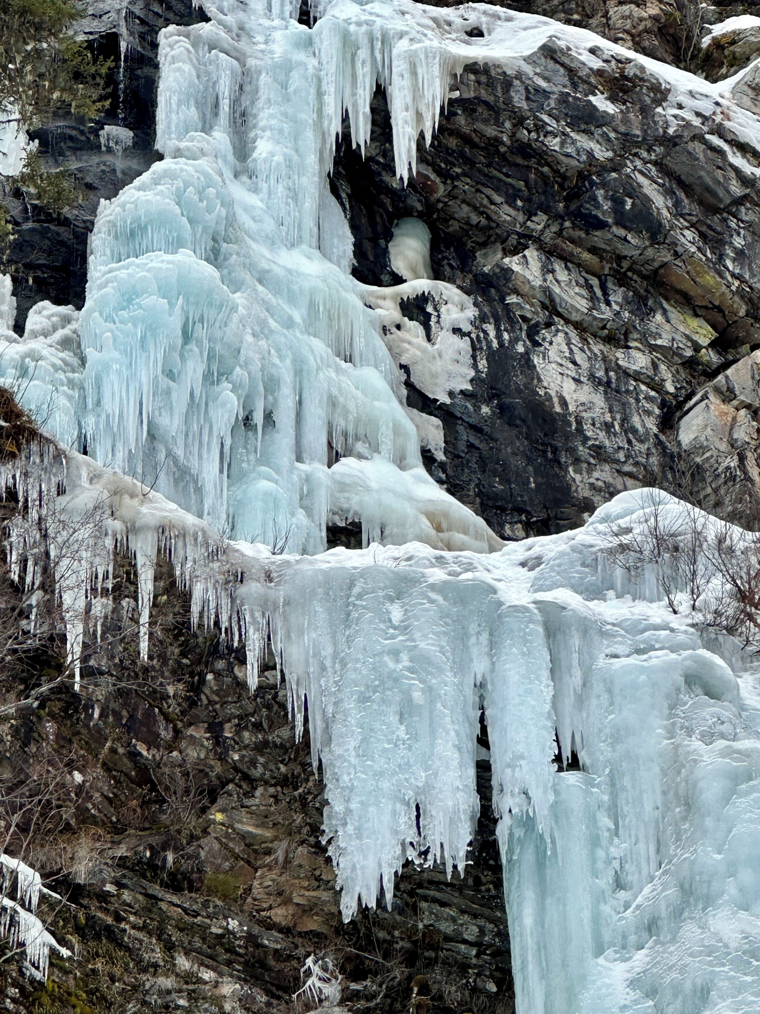A rocky landscape with icicles hanging from the cliff.