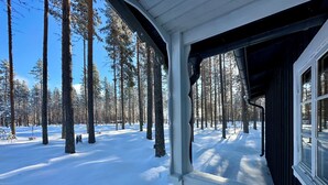 Une forêt enneigée avec une cabane en bois.