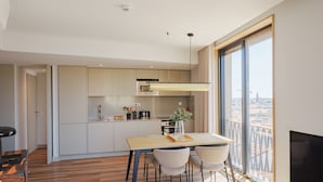 Eine moderne Küche mit Essbereich, großen Fenstern und Blick auf die Stadt.