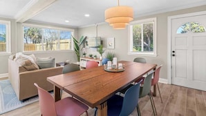 Un comedor con una mesa de madera, sillas y una lámpara colgante.