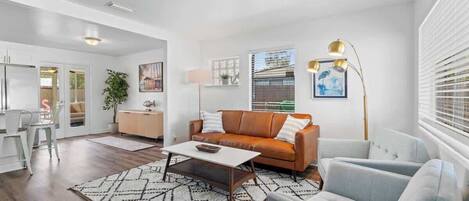 Uma sala de estar moderna com sofá, poltronas, mesa de centro e abajur.