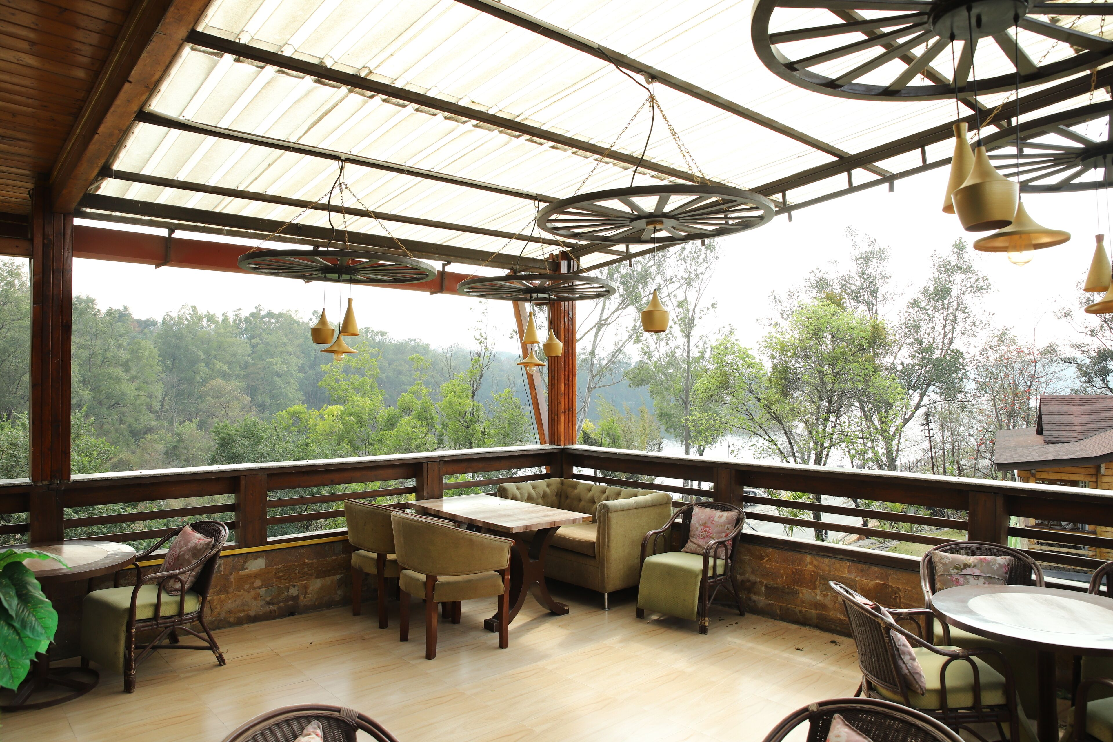 A wooden deck with a table and chairs, overlooking a forested area.