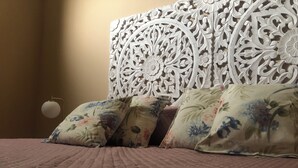 A bed with floral-patterned pillows and a textured bedspread. - CasaLotto Holiday Home Reggio Calabria (Reggio Calabria)