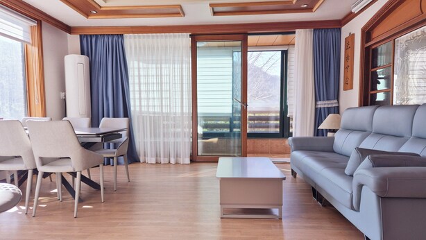 Un salon moderne comprenant un canapé, des fauteuils, une table basse et un coin repas.