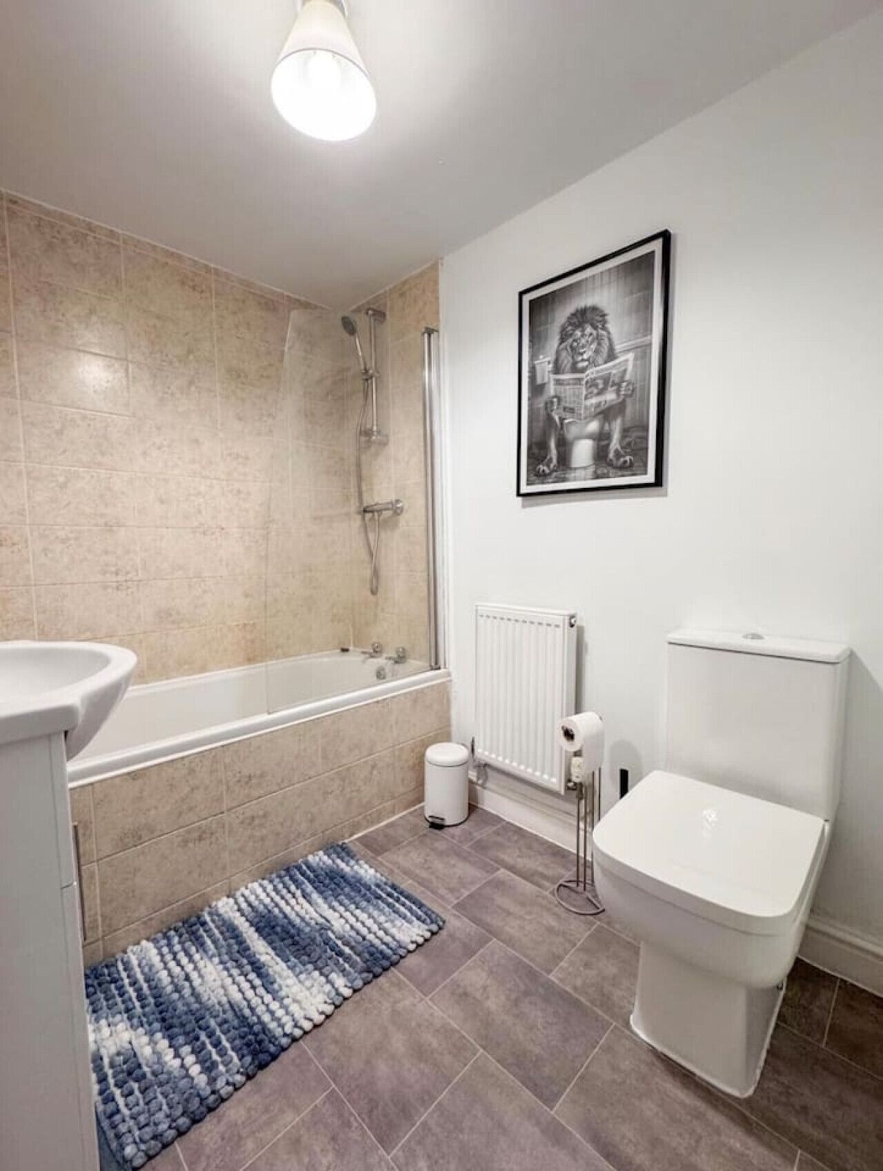 Een moderne badkamer met een bad, toilet en douche.