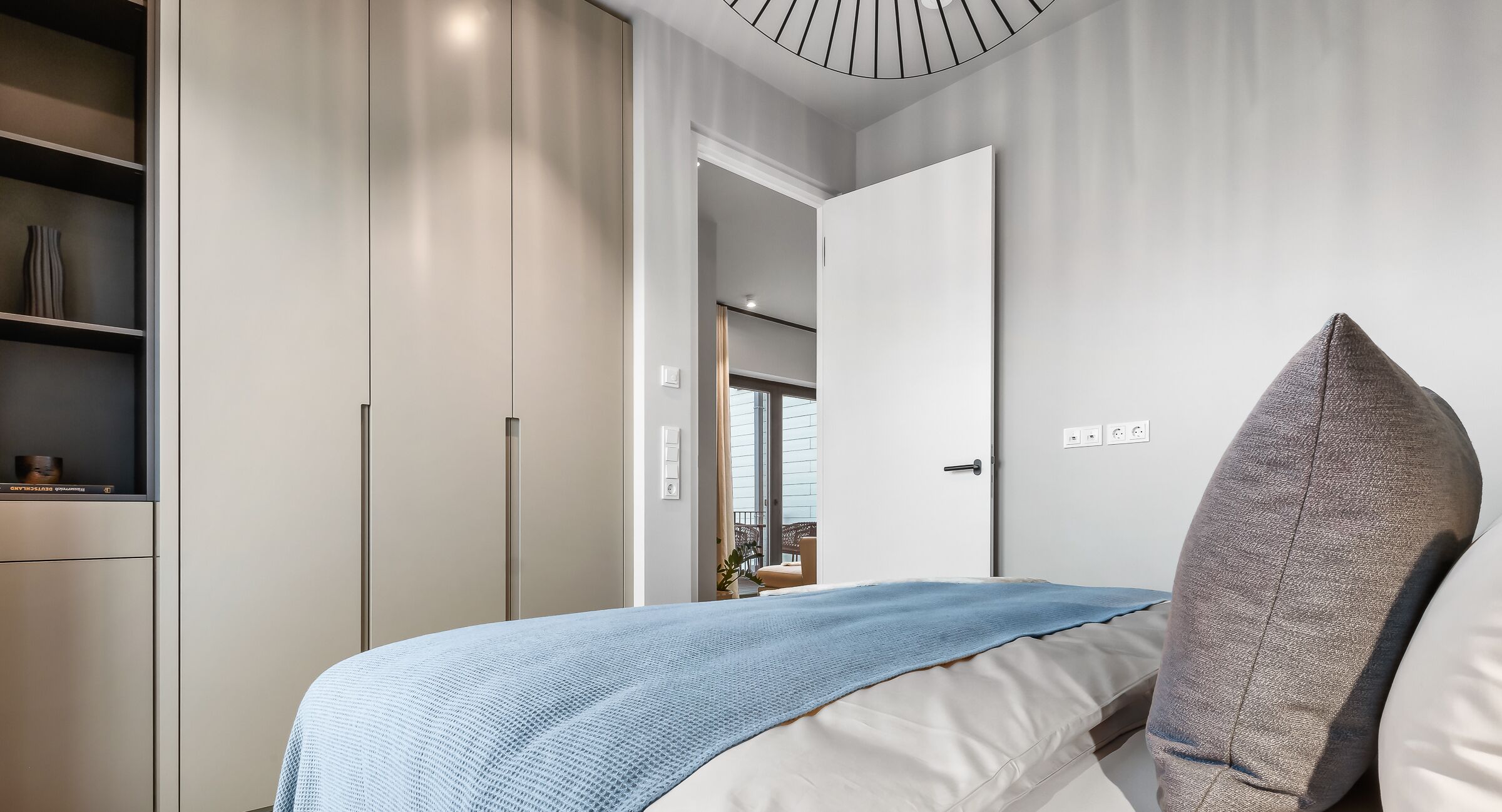 Un dormitorio con cama, armario y puerta que da a otra habitación.