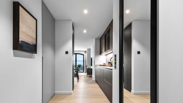 Une cuisine moderne avec des meubles de couleur sombre, un plan de travail et une fenĂŞtre.