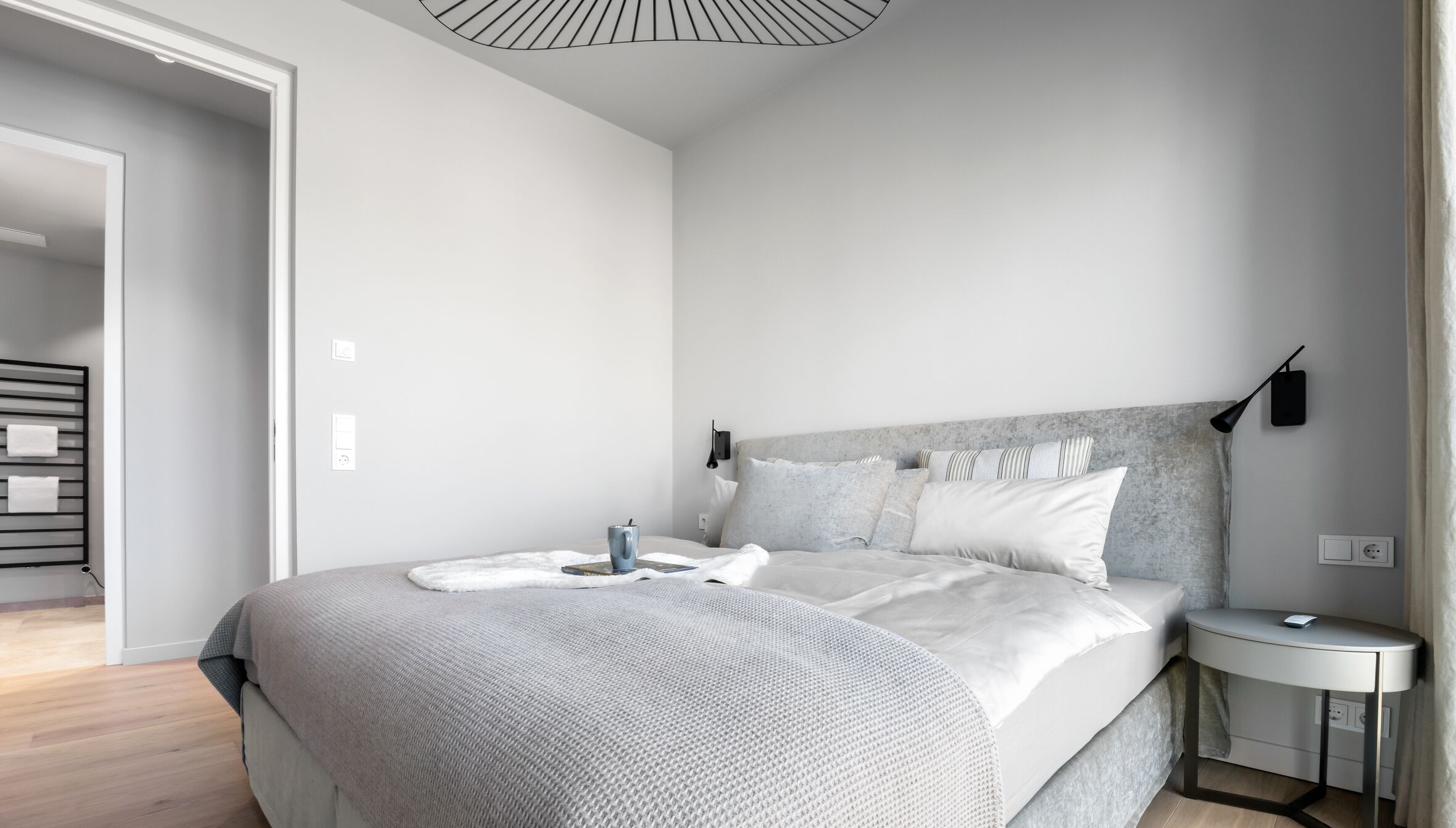 Een moderne slaapkamer met een groot bed, nachtkastjes en een inbouwkast.