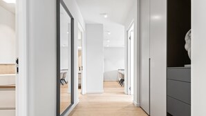 Un intérieur moderne avec un couloir menant à une salle à manger et à une cuisine.