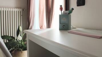 A white desk with a keyboard, a small plant, and a box of Kleisticker stickers.