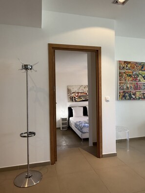 A modern bedroom with a bed, bedside table, and a floor lamp.