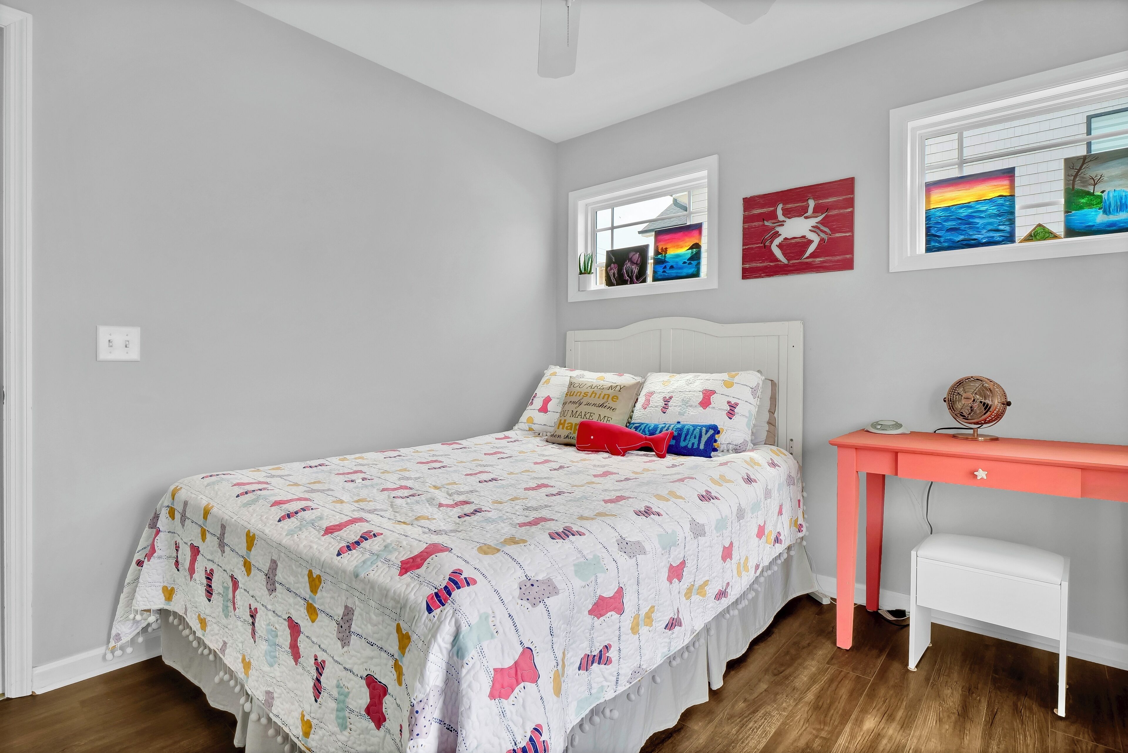 Een slaapkamer met een bed, bureau en raam.