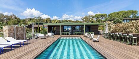 Una piscina al aire libre de temporada, sombrillas