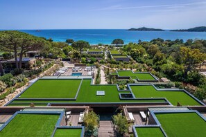 A resort with multiple green-roofed buildings, a central pool, and a view of the sea. - Hôtel VILLA MAIER (Zonza)