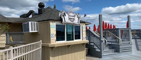 Un puesto de helados en la playa con un cartel que dice "Jamaica Now" y precios para conos de helado.