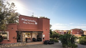 A Maristella Village Vacances building with a reception area, outdoor seating, and a clear sky. - Ferienhotel Maristella  (Aregno)