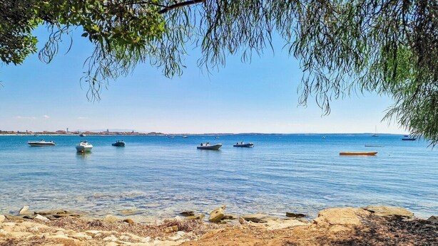 A beach with boats on the water and rocky shoreline. - Cozy Beachfront House with Stunning Sea View | Mandriola - Putzu Idu (Mandriola)