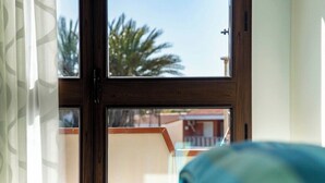 Ein Fenster mit Blick auf ein Gebäude und Palmen.