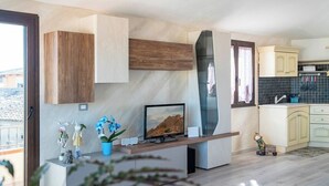 Eine moderne Küche mit Einbauherd, Flachbildfernseher und einer kleinen Essecke.