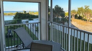 A balcony with a view of a beach and water. - SAND CAPER 202 - 2B/2B ISLAND CONDO! (Fort Myers Beach)