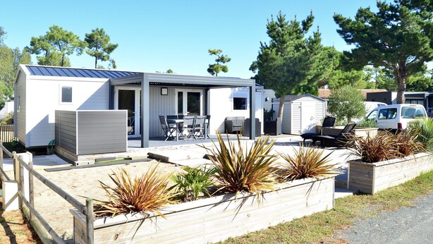 A mobile home with a patio area, outdoor seating, and a garden with various plants. - Chalet for 6 in St-Hilaire - Heated swimming pool (Saint-Hilaire-de-Riez)