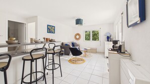 Eine moderne Küche mit Essbereich, Barhocker und einer Kaffeemaschine.