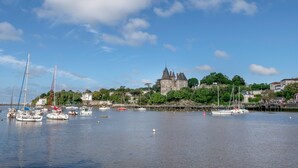 Ein Hafen mit Booten, einer Burg und einem klaren Himmel.
