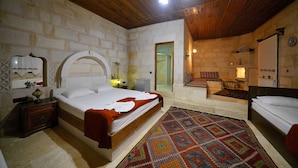 A room with a large bed, a smaller bed, a wooden ceiling, and a patterned rug. - Glory Art Stone House (Nevsehir)
