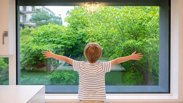 A child standing by a window with arms outstretched, overlooking a lush green garden. - Maison de Pepperoni Cheongdam N.5 Romantic Retreat in Gangnam, Garden View! (서울시)