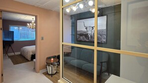 A modern office space with a glass partition, a sofa, a desk, and a chandelier. - Maison de Pepperoni Cheongdam N.5 Romantic Retreat in Gangnam, Garden View! (서울시)