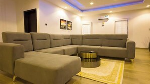 Una sala de estar moderna con un sofá modular, una mesa de centro y un tapete decorativo.