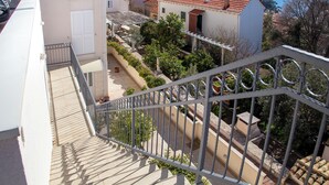 A balcony with a metal railing overlooking a coastal town with terracotta rooftops and a view of the sea. - Room Beta with sea view (Dubrovnik)