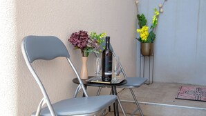 A small outdoor seating area with two chairs, a table, a bottle of wine, and two potted plants. - Room Beta with sea view (Dubrovnik)