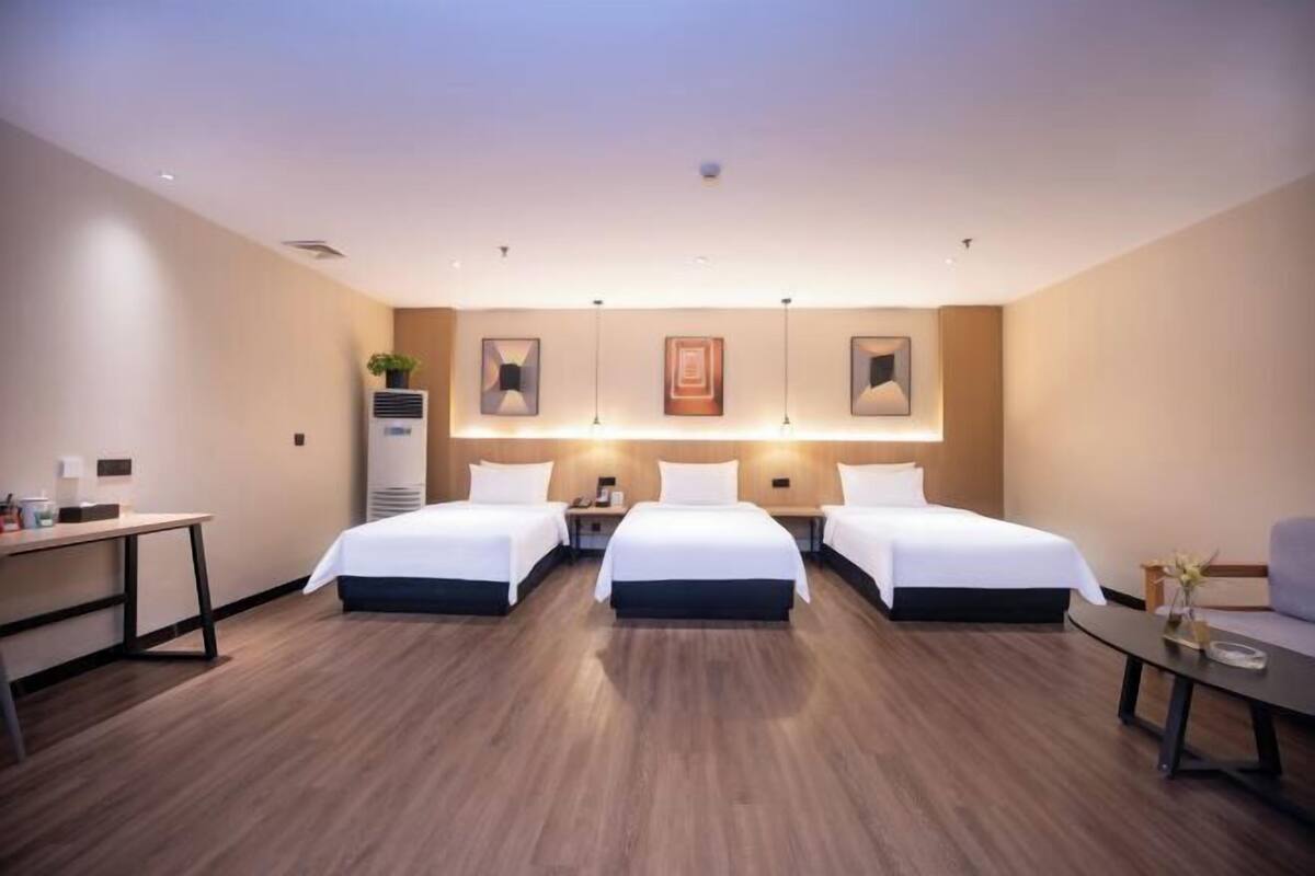 Una habitación de hotel con dos camas, un escritorio y una mesita.