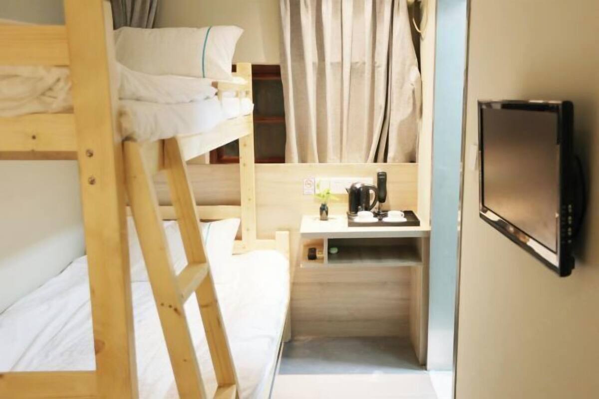 Habitación con literas, escritorio y televisor.