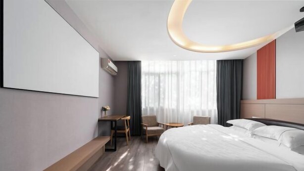 Una habitación de hotel moderna con una cama grande, un escritorio y una silla.