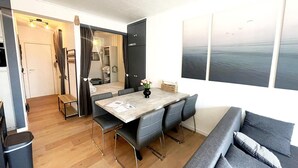 A modern, compact living space with a dining area, a sofa, and a large window with a view. - Apartment Near Boat Club in Middelkerke (Middelkerke)
